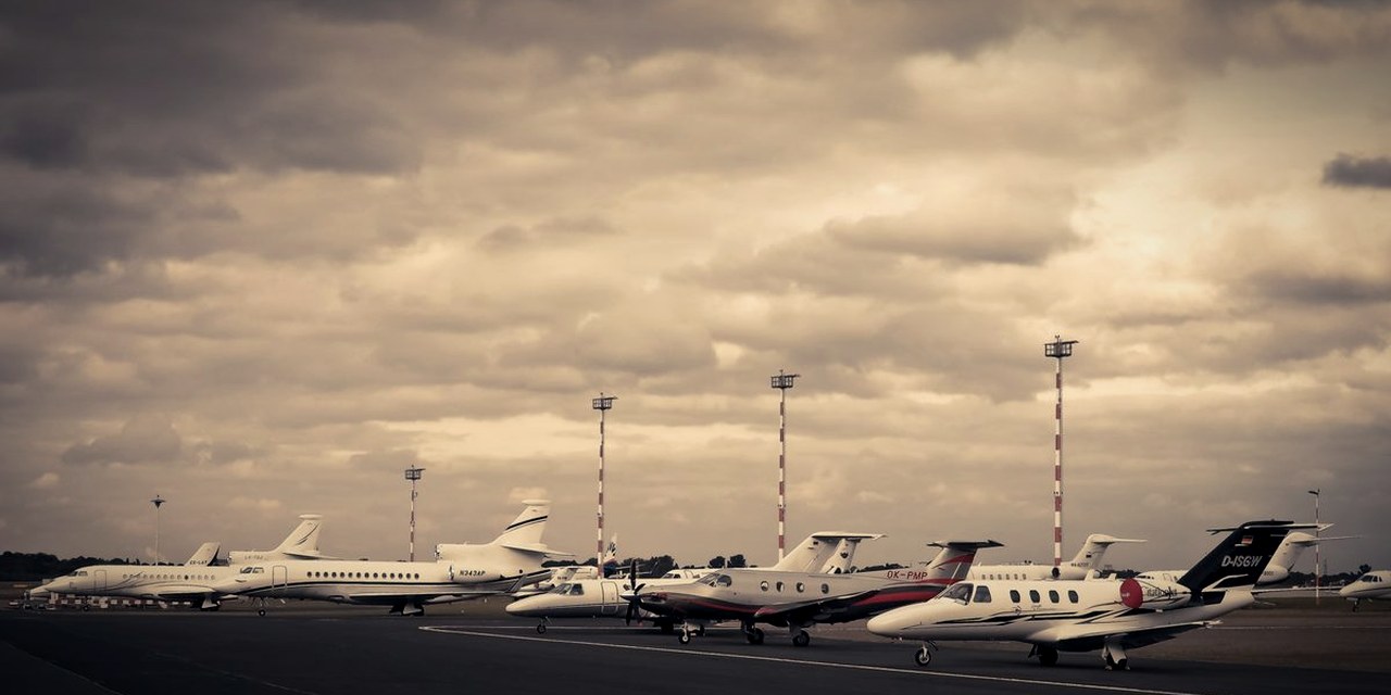 Multiple private jets lined up on airport ramp