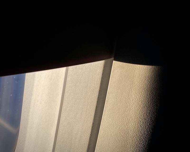 Aircraft window shade and panel at golden hour
